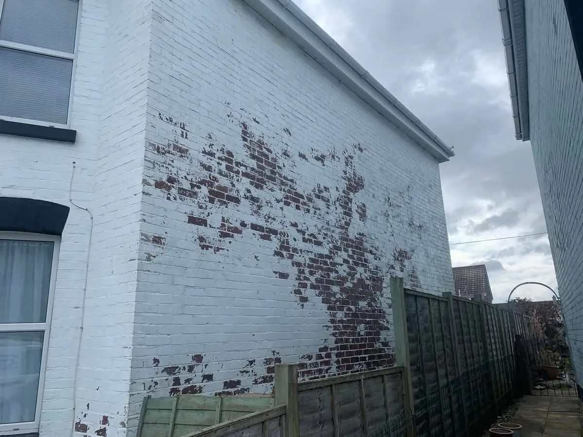 Peeling paint on a brick wall before redecoration in Torpoint